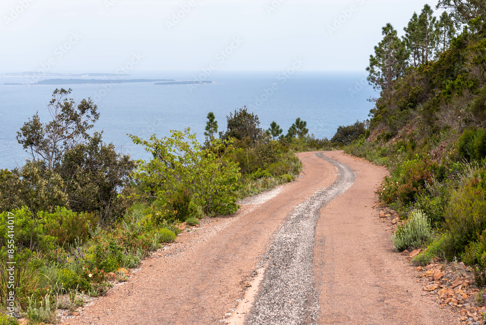 Road in the middle of the Esterel volcanic massif with the Mediterranean Sea in background (Saint-Raphael, Var, Provence-Alpes-Cote-d’Azur, France) Road in the middle of the Esterel volcanic massif with the Mediterranean Sea in background (Saint-Raphael, Var, Provence-Alpes-Cote-d’Azur, France)