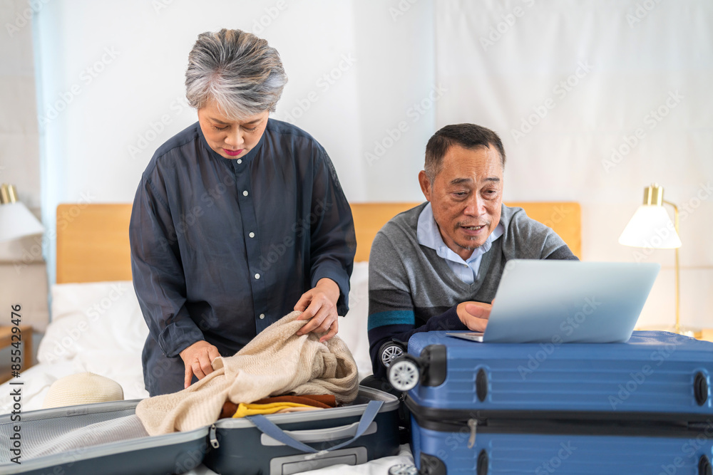 Senior elderly asian couple use laptop for hotel and resort booking online summer holiday travel planning searching information weekend vacation trip.reservation online, senior retirement concept Senior elderly asian couple use laptop for hotel and resort booking online summer holiday travel planning searching information weekend vacation trip.reservation online, senior retirement concept