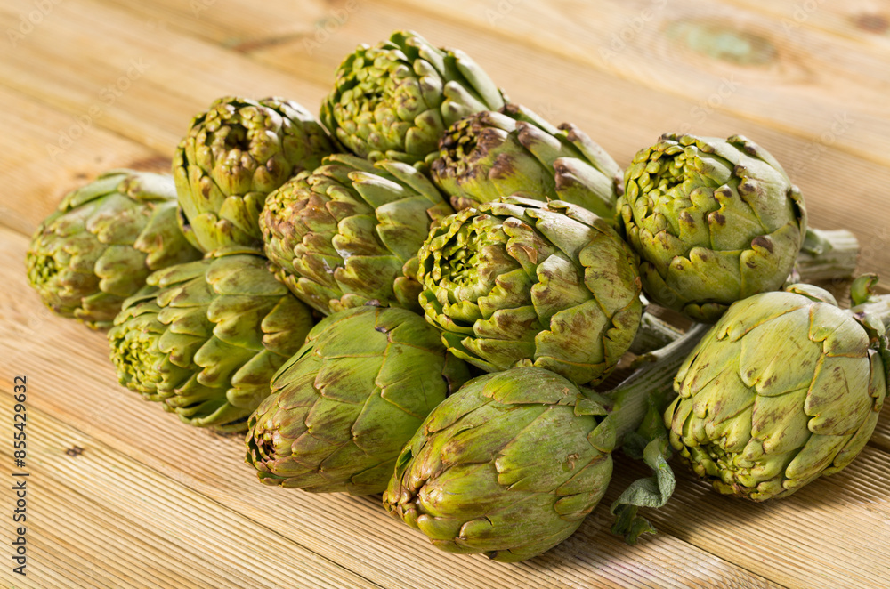Fototapeta premium Fresh ripe artichokes on wooden background
