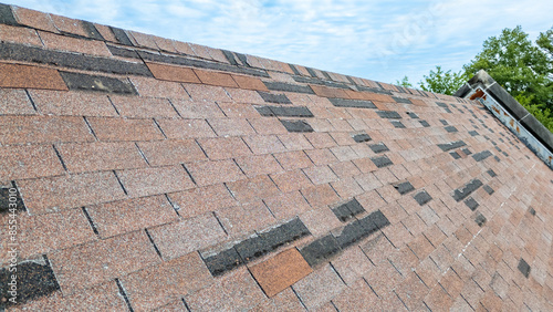 Roof with missing shingles from storm damage and old age