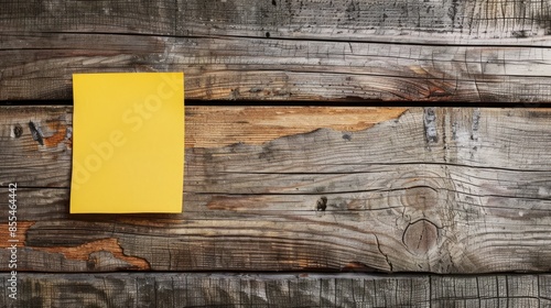 Handwritten punk message on yellow sticky note attached to a wooden wall photo