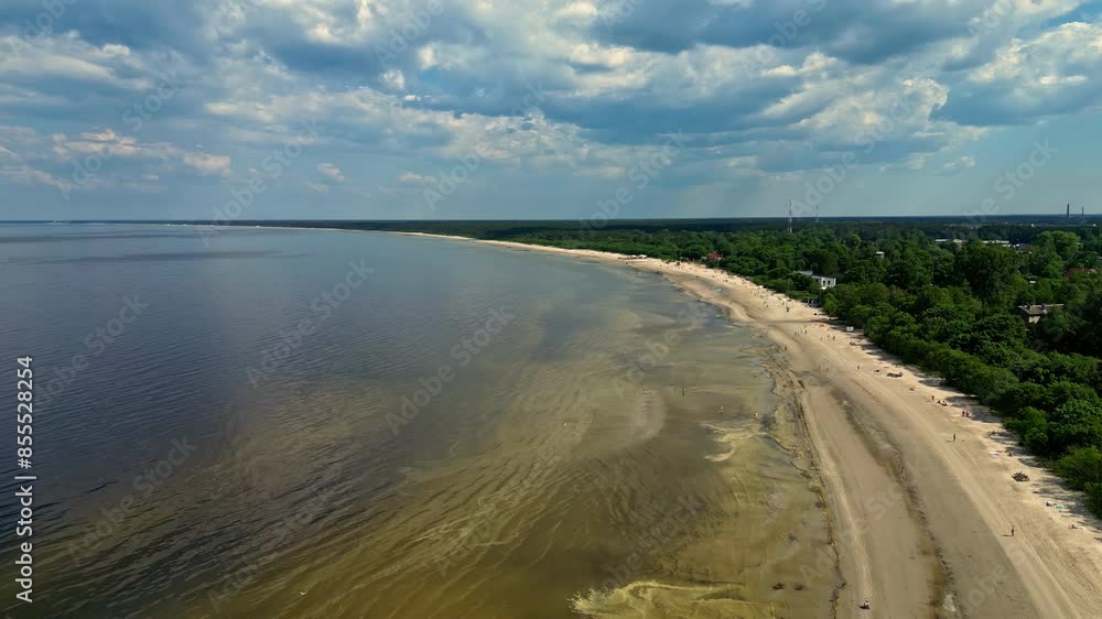 Aerial drone shot flying high over sandy beach along the coastline covered with dense green vegetation on sunny day. Aerial drone shot flying high over sandy beach along the coastline covered with dense green vegetation on sunny day.