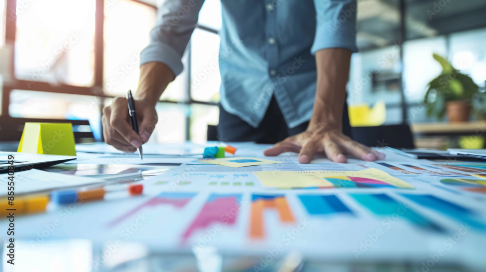 Business professional analyzing financial data with charts and graphs on a desk, focusing on growth and strategic planning in an office setting. Business professional analyzing financial data with charts and graphs on a desk, focusing on growth and strategic planning in an office setting.