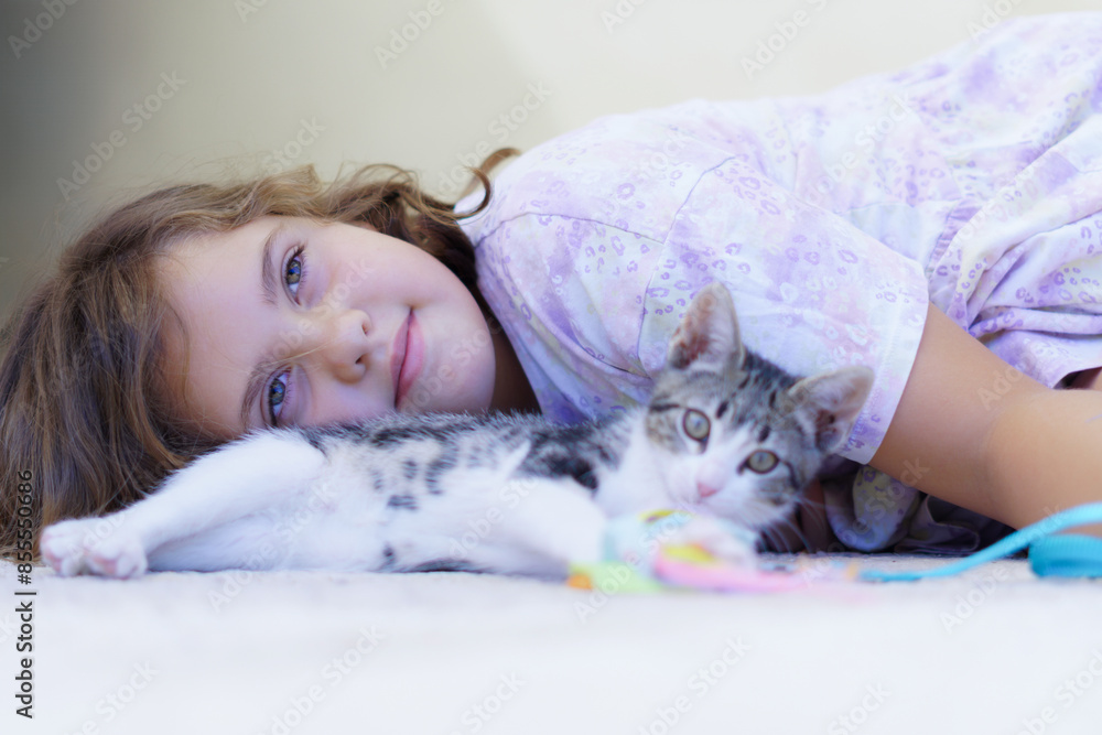 beautiful little girl lying on the ground looking up at the sky pensive with her little cat beautiful little girl lying on the ground looking up at the sky pensive with her little cat