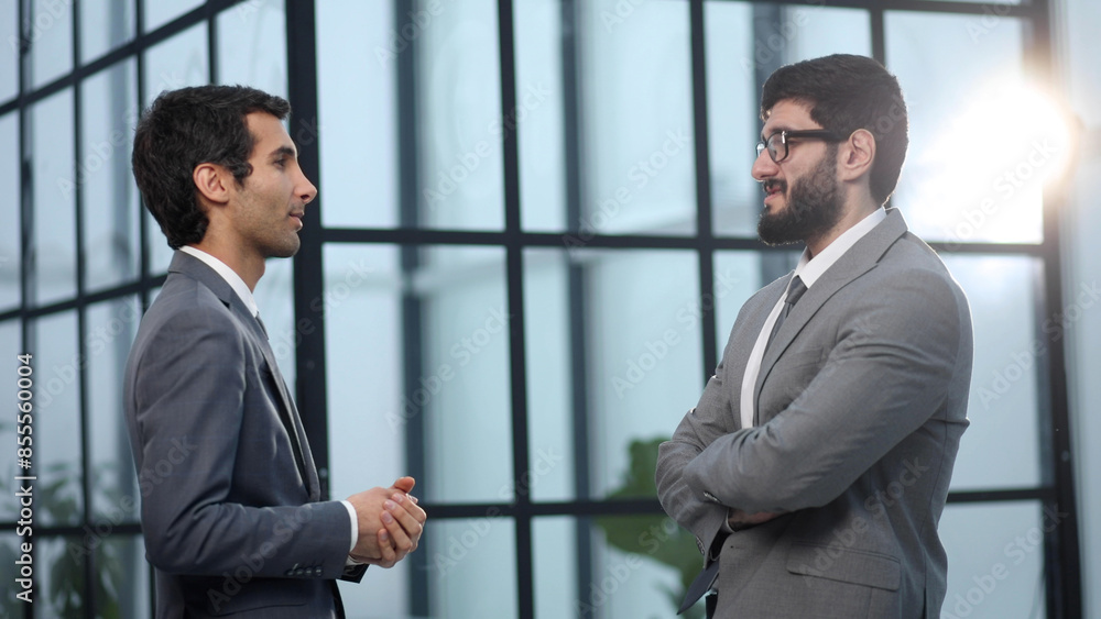 Two businessmen discussing project at meeting at office. Two businessmen discussing project at meeting at office.