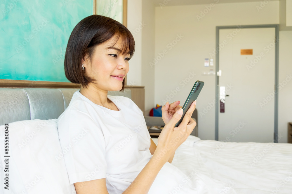 Smiling woman relaxes on a couch, browsing her tablet at home Smiling woman relaxes on a couch, browsing her tablet at home