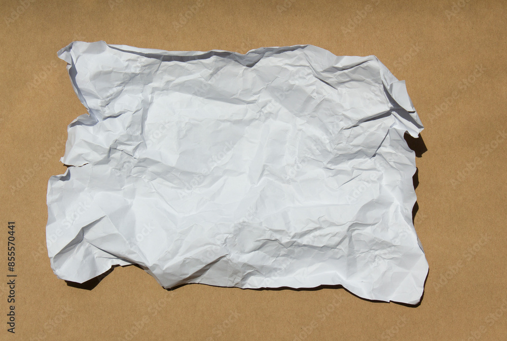 Crumpled paper lying on a brown background.
Crumpled paper lying on a brown background.
