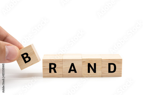 Hand place wooden blocks with BRAND text isolated on white background. Build your Brand. Brand building, success, business. Copy space and clipping path. photo