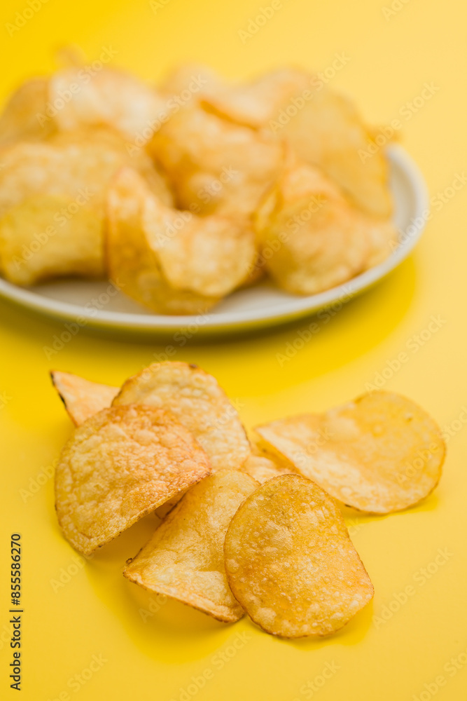 Crispy Potato Chips on Yellow Background Crispy Potato Chips on Yellow Background