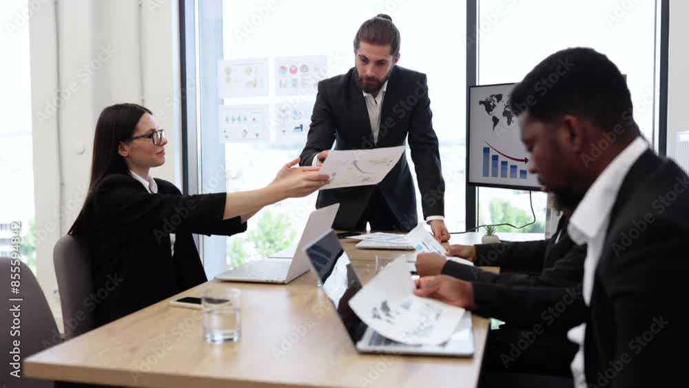 Diverse business team discussing financial graphs in modern office. Colleagues in formal attire collaborating on company strategy. Professional work environment with charts and statistics displayed. Diverse business team discussing financial graphs in modern office. Colleagues in formal attire collaborating on company strategy. Professional work environment with charts and statistics displayed.
