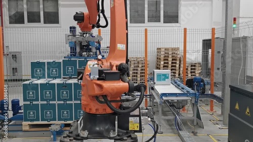  Robot palletizer orange KUKA robot kr180 stacks boxes on a pallet photo