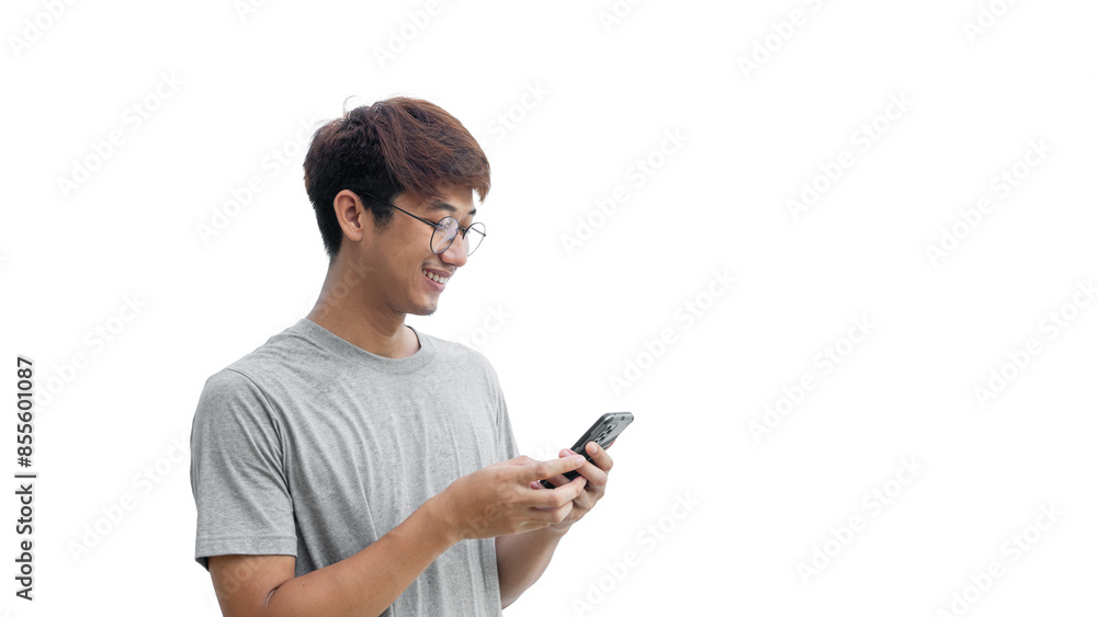 Young Asian man in his 20s wear glasses and wearing a gray t-shirt is happily playing on a mobile phone isolated on a white background. Typing and chatting with friends via smartphone. Online social Young Asian man in his 20s wear glasses and wearing a gray t-shirt is happily playing on a mobile phone isolated on a white background. Typing and chatting with friends via smartphone. Online social