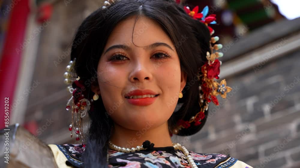 Portrait of young Chinese woman wearing traditional Qing hairstyle smiles at camera Portrait of young Chinese woman wearing traditional Qing hairstyle smiles at camera