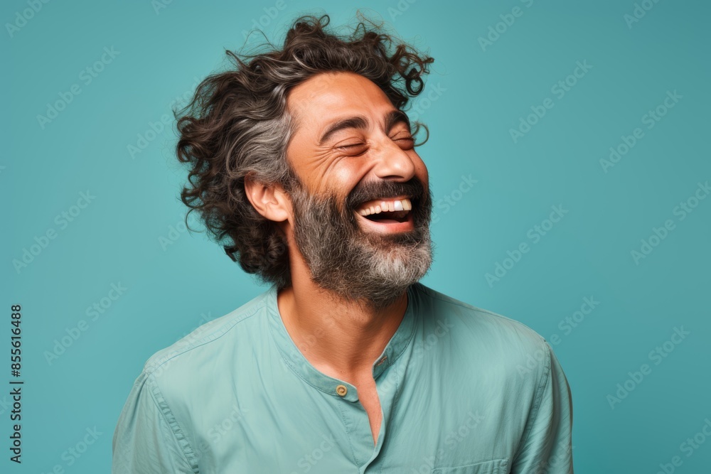 The happy Middle Eastern man, 46 years old, winking on a pastel teal background The happy Middle Eastern man, 46 years old, winking on a pastel teal background