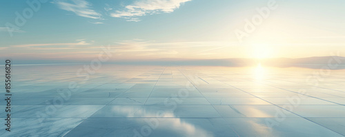 Wallpaper Mural A large body of water with a sun setting in the background. The sky is clear and blue with a few clouds. The water is calm and still, reflecting the sun's rays. The scene is peaceful and serene Torontodigital.ca