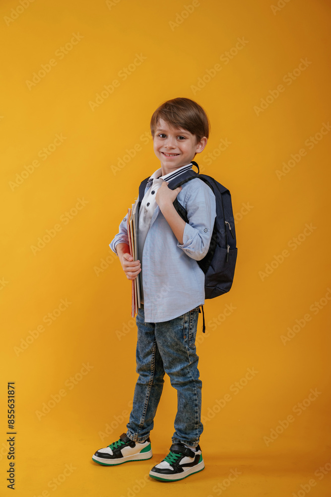 Little boy is in the studio against yellow background Little boy is in the studio against yellow background