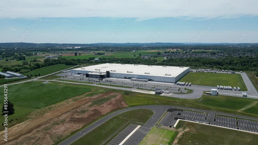 Aerial drone view of business park that includes warehouses, factories, and gas station.