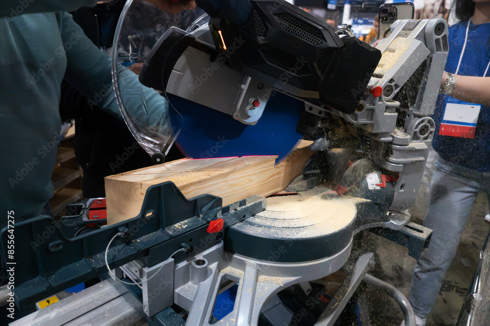A worker cuts a wooden block using a circular saw. A worker cuts a wooden block using a circular saw.