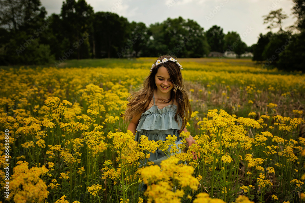 Happy young girl laughing in field of yellow flowers blue sky Happy young girl laughing in field of yellow flowers blue sky