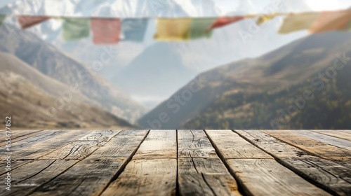 a close up of a rustic empty wooden table with blurred tibetan mountains with mahakala prayer flags background
