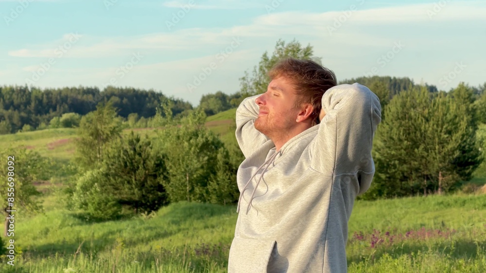 Young man enjoying nature at summer day in the park or forest, deep breath fresh air Young man enjoying nature at summer day in the park or forest, deep breath fresh air