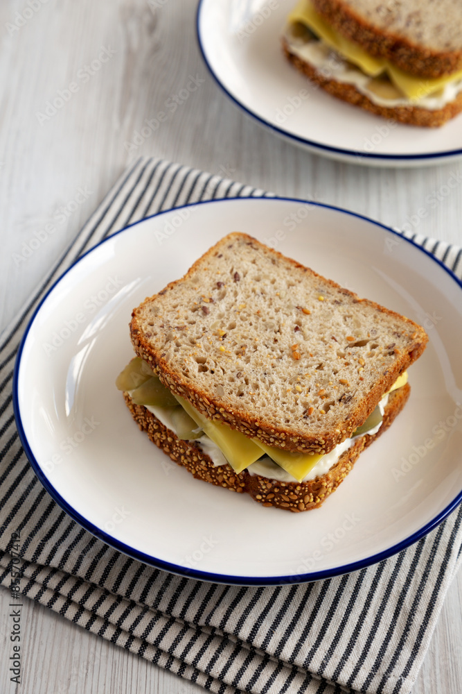 Homemade Pickle Sandwich with Mayo and Cheese on a Plate, side view. Homemade Pickle Sandwich with Mayo and Cheese on a Plate, side view.