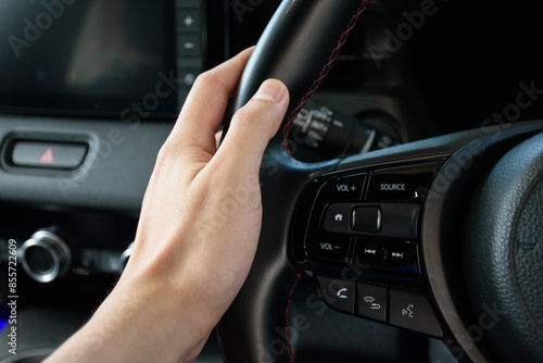 Close up of a man hand on the steering wheel of a modern car and luxurious car in 2024.