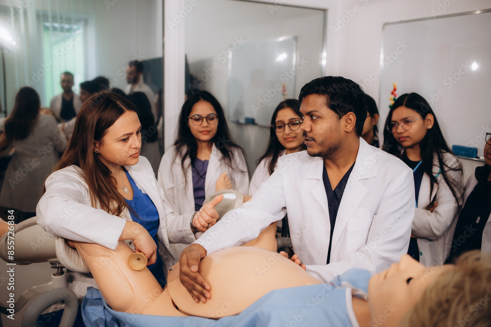 students pass the practice of delivering a baby on a dummy at a medical university students pass the practice of delivering a baby on a dummy at a medical university
