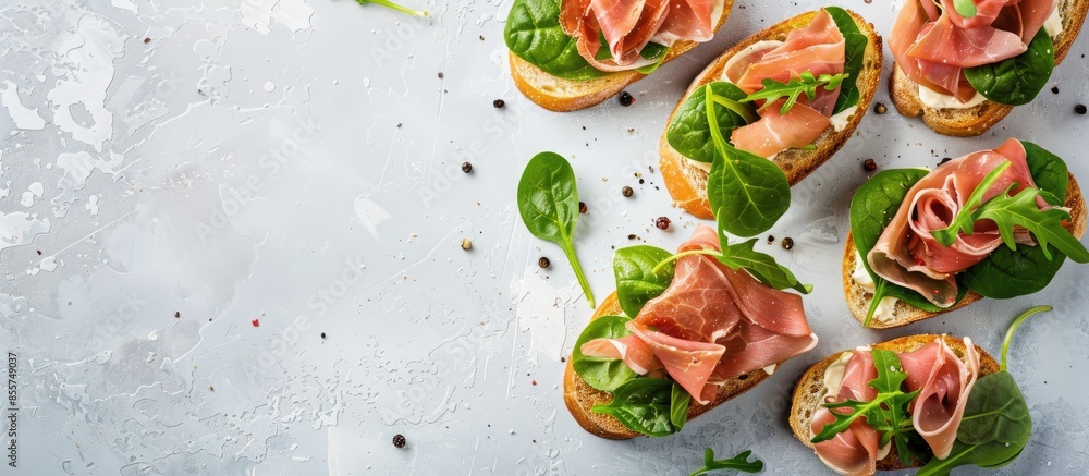 Tasty ham, jamon bruschettas with lettuce and spinach on pastel background. with copy space image. Place for adding text or design Tasty ham, jamon bruschettas with lettuce and spinach on pastel background. with copy space image. Place for adding text or design