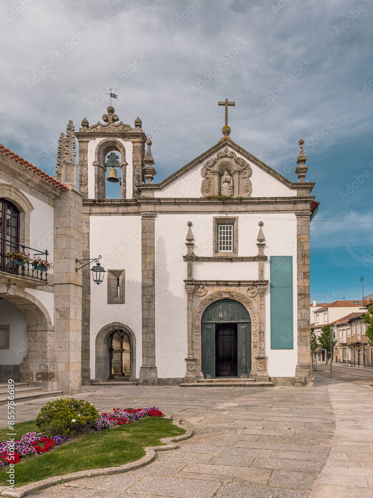 Fototapeta premium Facade of Mercy Church with Renaissance entrance portal and door open, pediment with saint and bell tower, Caminha, Viana do Castelo district, north of Portugal