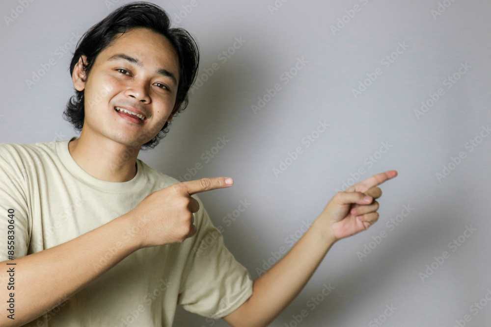 Portrait of an Asian Indonesian young man wearing a white shirt with a random expression when photographed with an isolated white background Portrait of an Asian Indonesian young man wearing a white shirt with a random expression when photographed with an isolated white background