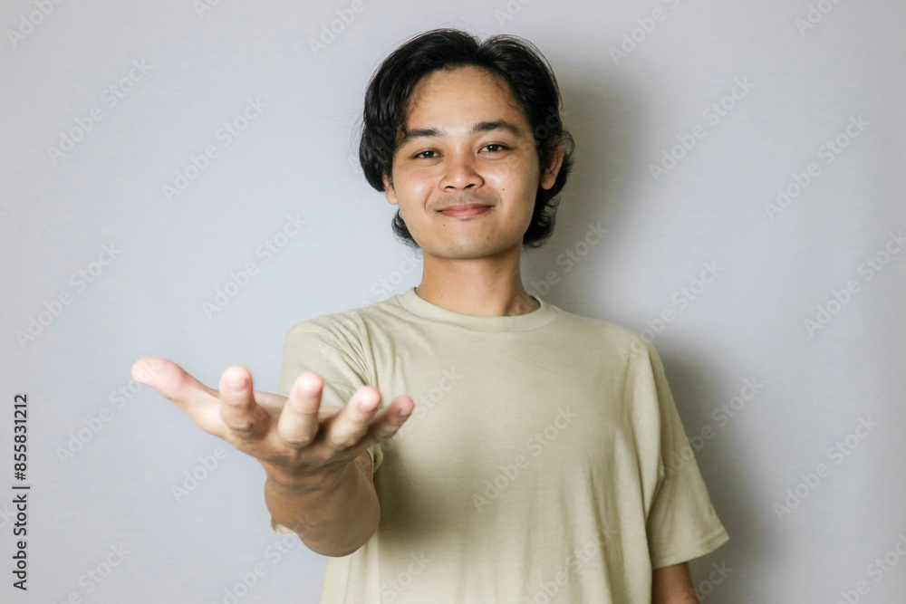 Portrait of an Asian Indonesian young man wearing a white shirt with a random expression when photographed with an isolated white background Portrait of an Asian Indonesian young man wearing a white shirt with a random expression when photographed with an isolated white background