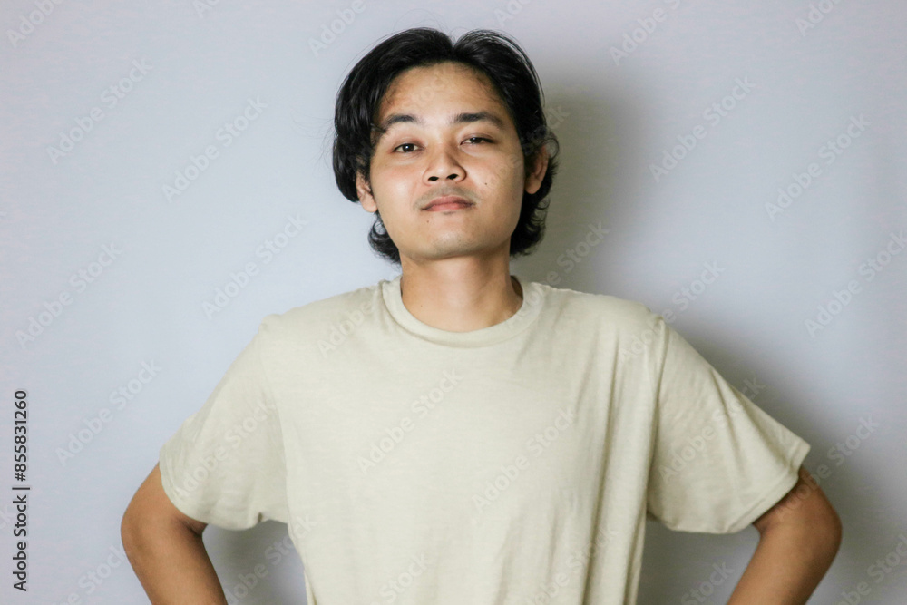 Portrait of an Asian Indonesian young man wearing a white shirt with a random expression when photographed with an isolated white background Portrait of an Asian Indonesian young man wearing a white shirt with a random expression when photographed with an isolated white background