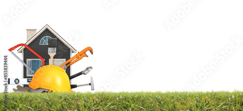 Yellow hardhat and old leather gloves and model house grass as fokaw