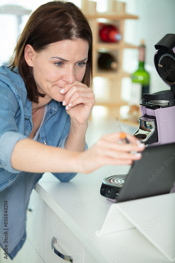 woman repair a coffee maker with screwdriver woman repair a coffee maker with screwdriver