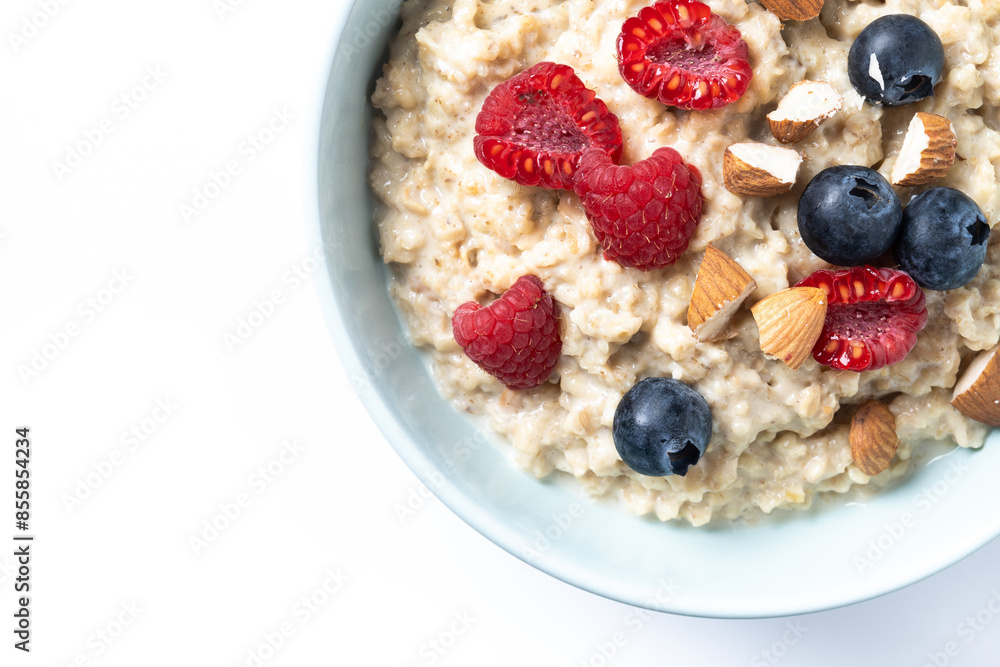 Oatmeal porridge with raspberries, blueberries and almonds in bowl isolated on white background Oatmeal porridge with raspberries, blueberries and almonds in bowl isolated on white background