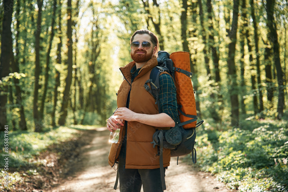 Enjoying warm weather and nature. Bearded man is in the forest at daytime Enjoying warm weather and nature. Bearded man is in the forest at daytime