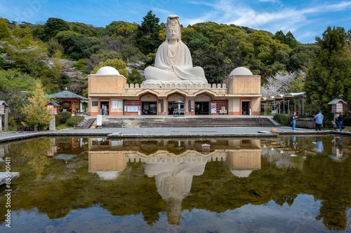 Serene view of the Ryozen Kannon statue in Kyoto, Japan with a reflection in a calm pond. photo