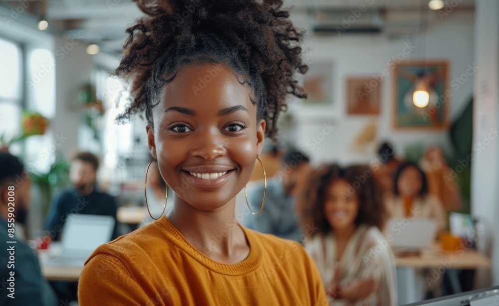 Happy black businesswoman standing in a modern office with a team working , smiling and looking at the camera Happy black businesswoman standing in a modern office with a team working , smiling and looking at the camera