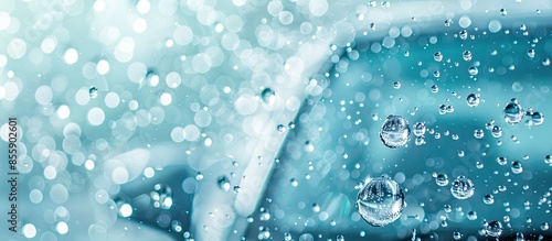 Abstract carwash banner, focus only on drops of water, jet spraying to car out of focus, toned in light blue color. Copy space image. Place for adding text and design