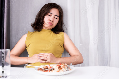 фотографія asian woman suffering from stomachache and discomfort after eating a meal, gastr