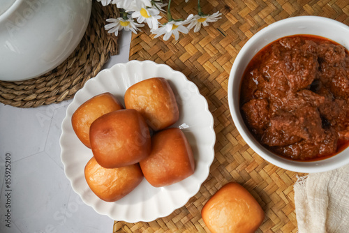 Fried Mantou served in white plate with Beef Rendang.  Fusion food. photo