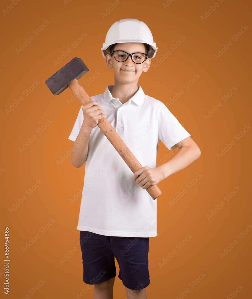 studio portrait of a Hindu boy worker in a hard hat with a hammeron a brown background . My future profession concept studio portrait of a Hindu boy worker in a hard hat with a hammeron a brown background . My future profession concept