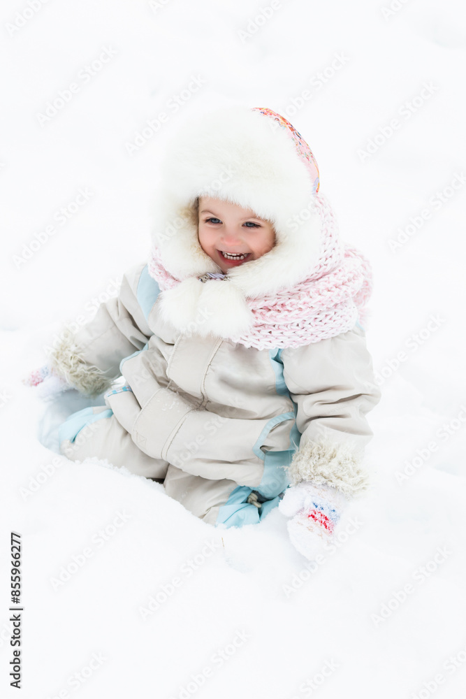 A cute baby in a snowy winter forest. Little girl having fun on winter day. Happy child in winter park A cute baby in a snowy winter forest. Little girl having fun on winter day. Happy child in winter park