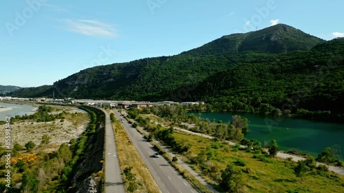 Drone footage of vehicles driving on Iscles road along Broc Lake on a sunny day in Le Broc, France photo