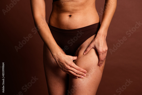 Cropped photo of imperfect fatty lady underwear lingery doing anti cellulite massage isolated brown color background © deagreez