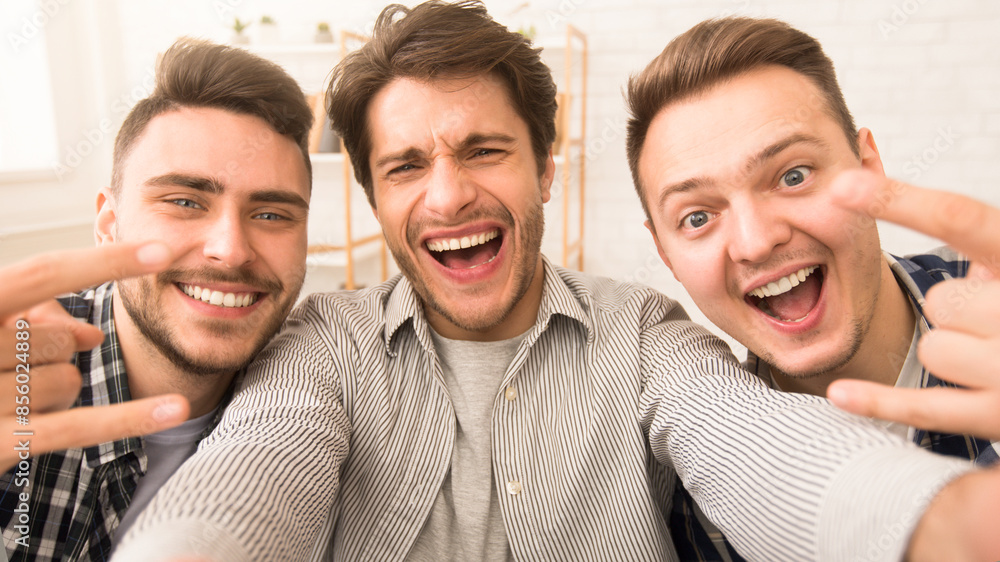 Three cheerful guys friends posing together, sharing a joyful moment with bright expressions and gestures Three cheerful guys friends posing together, sharing a joyful moment with bright expressions and gestures