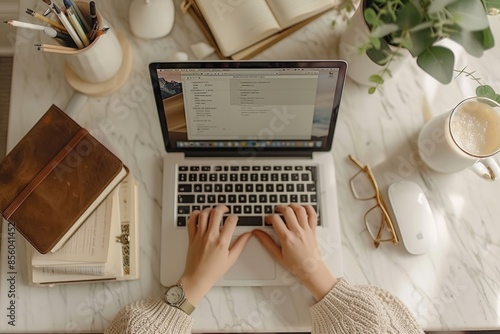 Freelancer Working on Laptop in Cozy Home Office, Coffee and Notebook on Desk, Overhead View. Hands with laptop Top view. Aesthetic lifestyle photo