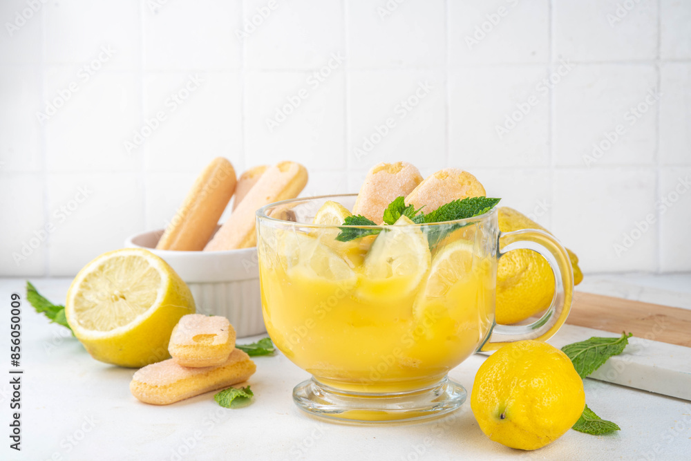 Fototapeta premium Lemon Pudding Dessert on Glass cup. Layered parfait dessert with cookies and lemon slices, copy space