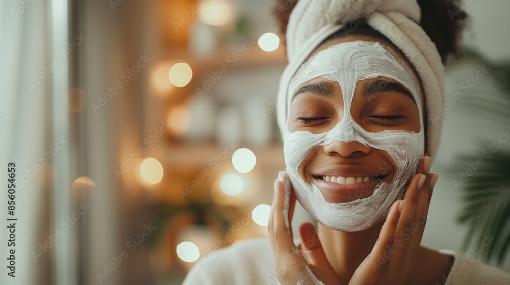 Joyful woman with a face mask on, eyes closed and hands touching her face, surrounded by warm lights Joyful woman with a face mask on, eyes closed and hands touching her face, surrounded by warm lights
